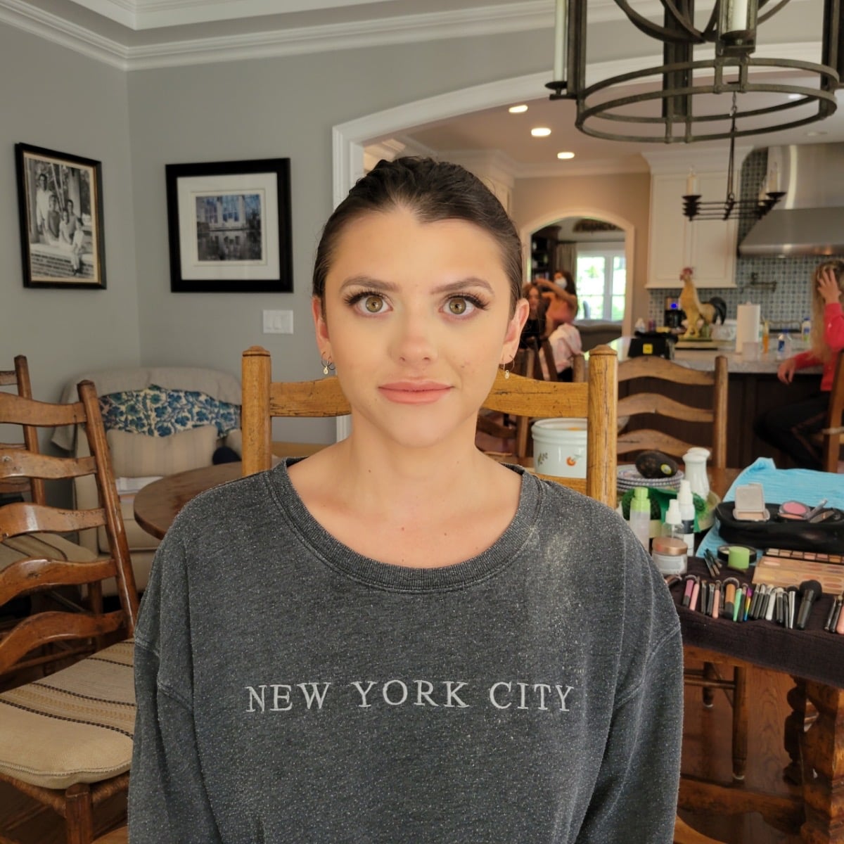 Radiant bride holding white bouquet among hydrangeas with natural bridal makeup by Doorbell Salon