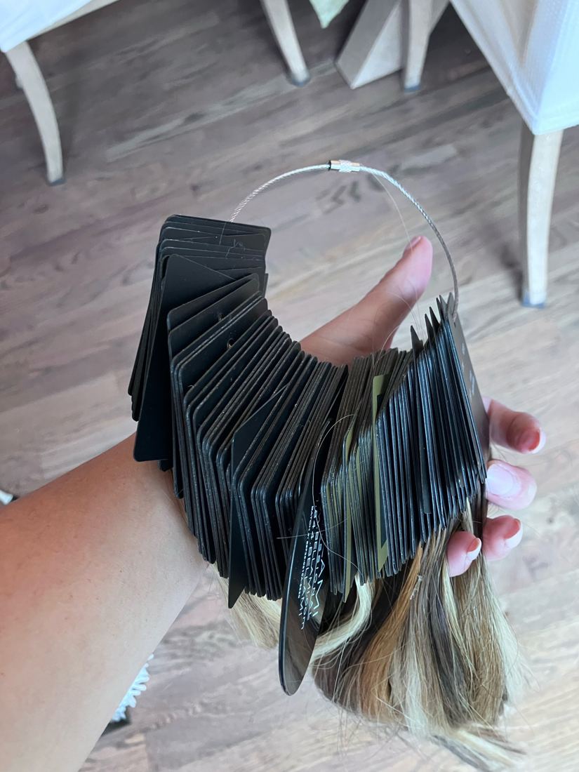 Full Bellami Professional extension color ring held during an in-home consultation